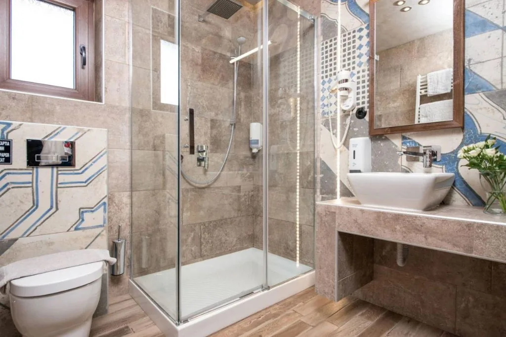 Bad mit Glasdusche und Fliesen im Mosaikstil